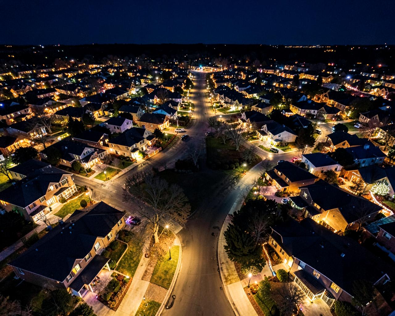 Aerial view of a neighborhood with many homes lit for the holidays
